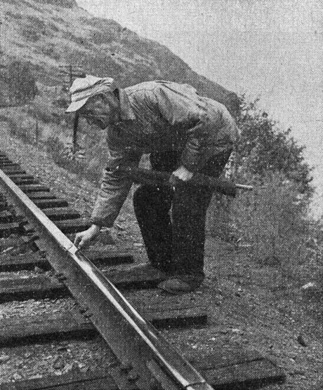 Flagman Nicholas Trnovsky places a torpedo on a rail.