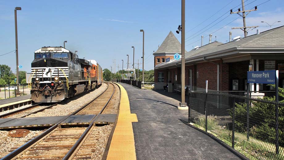 A CP freight with NS and BNSF units passes the Hanover Park station.