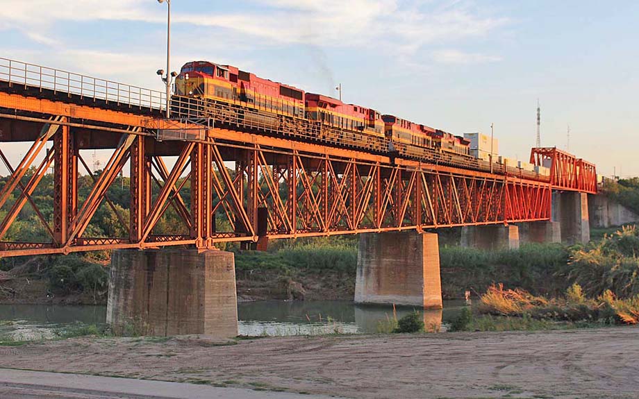 Four Kansas City Southern locomotives lead a northbound intermodal train across the Rio Grande.
