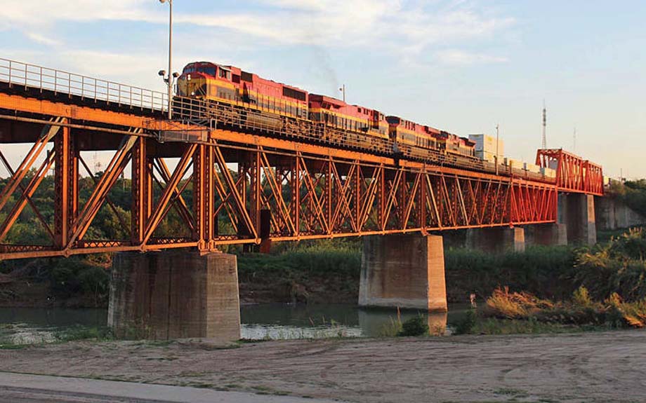 Four KCS units lead a northbound container train across the Rio Grande.