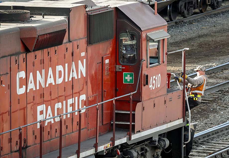 An employee boards a CPKC locomotive in Calgary.